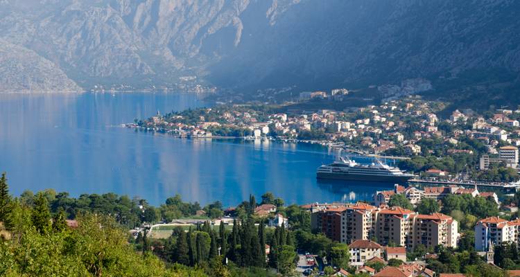Vue aérienne surplombant une baie entourée de montagnes et d'une ville.