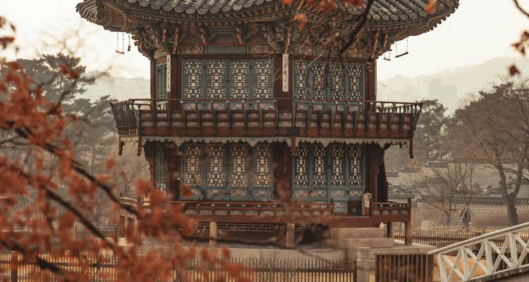 Traditional wooden pavilion surrounded by trees with an autumn setting.