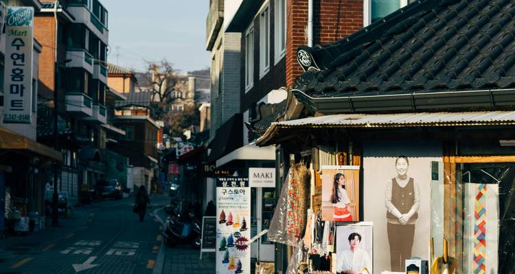 A street view with traditional architecture and various shop signs.