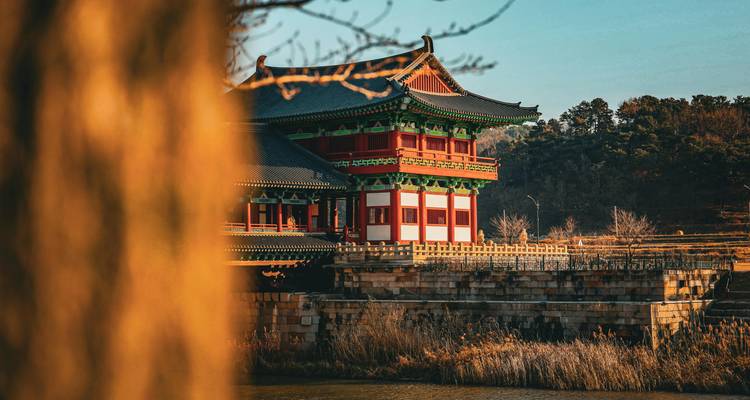Beautiful traditional building beside a river surrounded by nature.