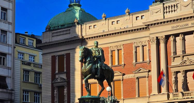 Statue of a rider on horseback in a city square.