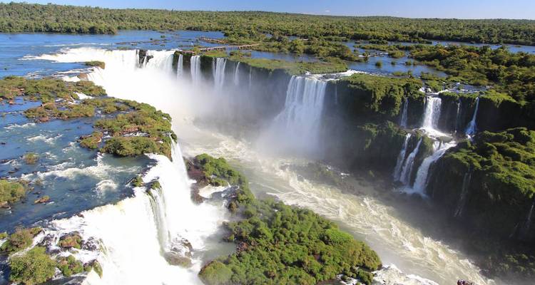 Aerial view of expansive waterfalls amidst lush greenery.