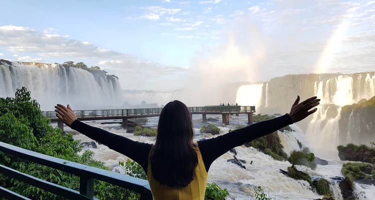 Person with outstretched arms enjoying the view of waterfalls.
