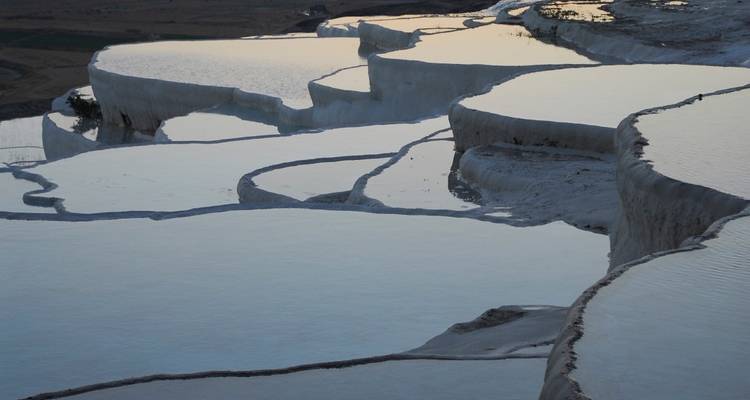 Natural travertine terraces filled with water.