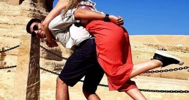 Couple posant de manière ludique avec des ruines antiques.