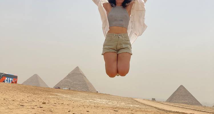 Personne sautant avec des pyramides en arrière-plan.