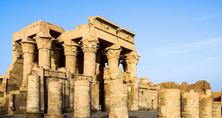 Oude Egyptische tempel met zuilen onder een heldere blauwe hemel.