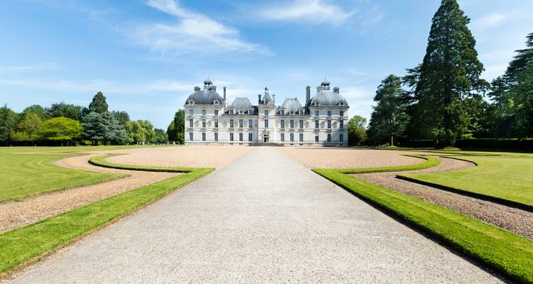 Vooraanzicht van een groots kasteel met een heldere blauwe lucht.
