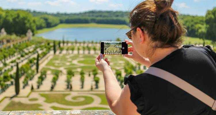 Persoon die een foto maakt met een smartphone van de tuinen.