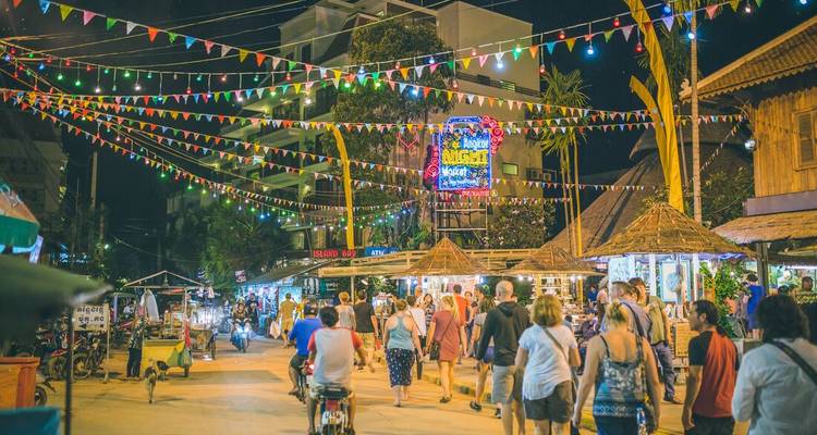 Lively night market with colorful lights and crowds of people.