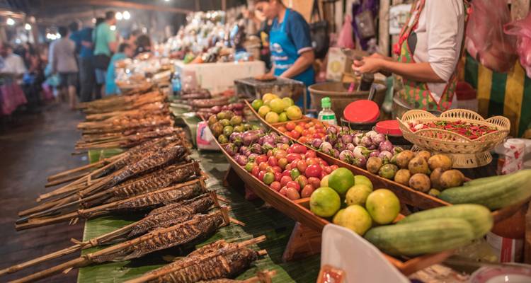 Levendige marktscène met verschillende vruchten en gegrilde vis