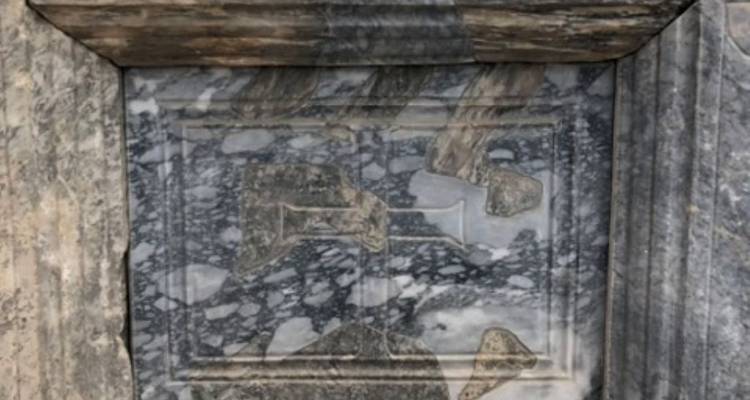 Marble slab with faded inscriptions and carvings.