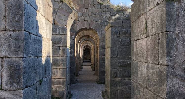 Ancient stone corridor with arches.
