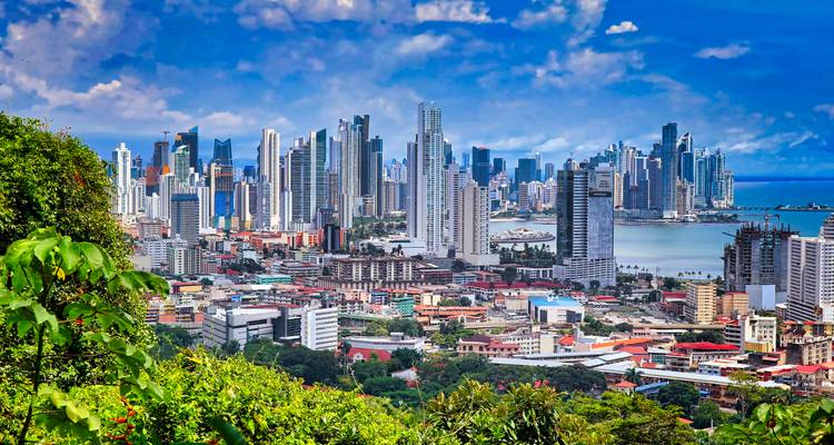 Vista panorámica del horizonte de la Ciudad de Panamá con edificios vibrantes y océano.