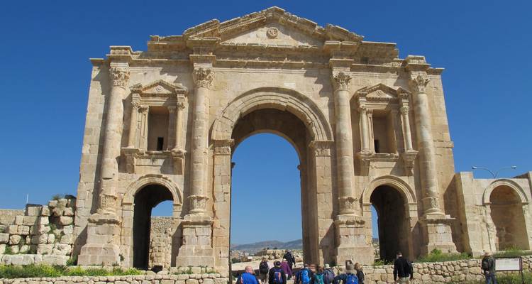 Arco romano con personas caminando por debajo.