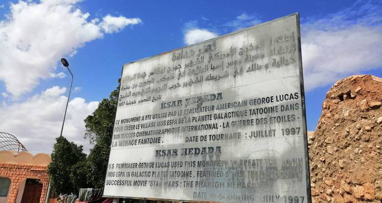 Panneau d'information sur un lieu de tournage situé dans un environnement désertique.