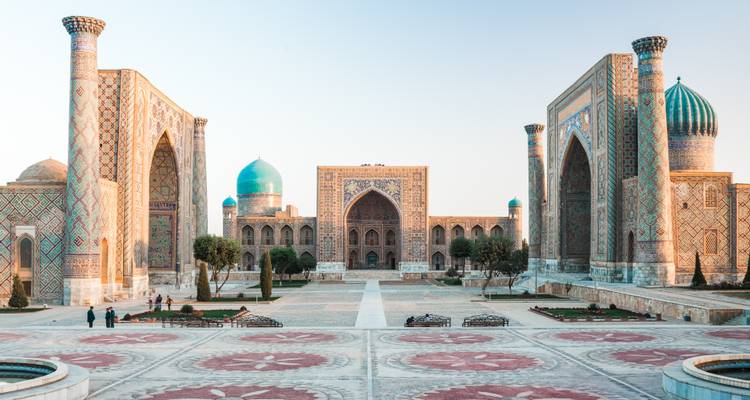 Large panorama de la place du Registan avec trois magnifiques madrasas dans la lumière douce du soir.