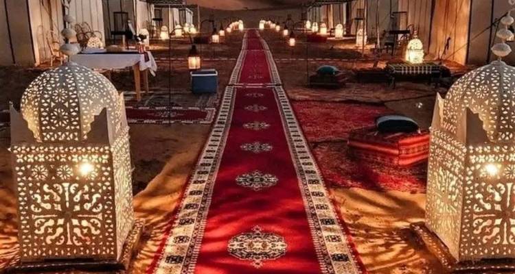 Scène désertique nocturne avec tentes et lanternes illuminées.