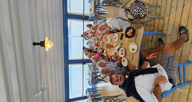 Grand groupe dînant à une longue table à l'intérieur d'un restaurant.