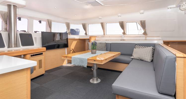 Intérieur d'un yacht montrant un coin repas avec de grandes fenêtres.