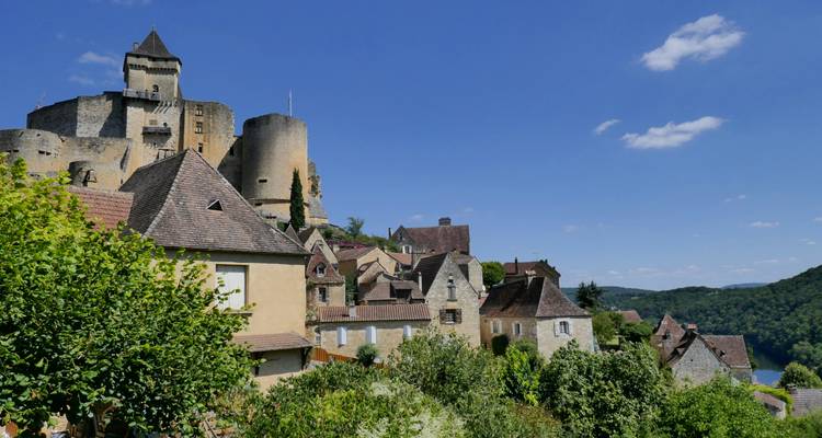 Charmantes Bergdorf mit einem Schloss, das die Landschaft überblickt.