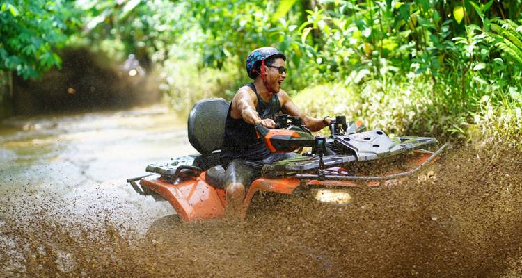 Personne conduisant un VTT sur un chemin boueux, éclaboussant de la boue.