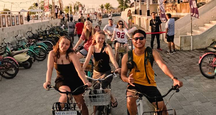 Groupe de personnes faisant du vélo sur une promenade au bord de l'eau.