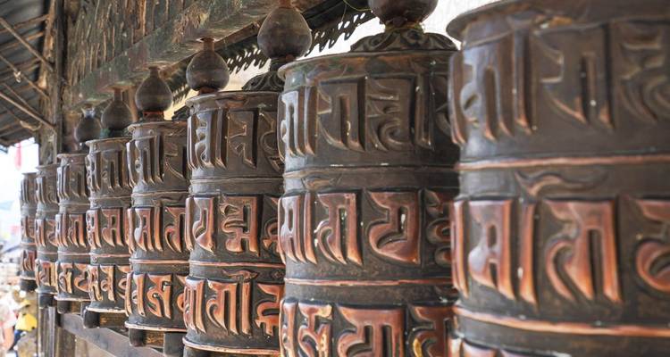 Rij traditionele gebedsmolens met inscripties.