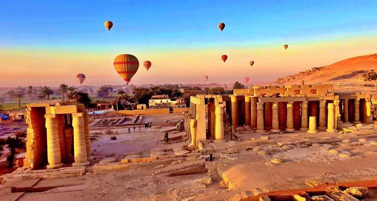 Heißluftballons über antiken Ruinen bei Sonnenaufgang.