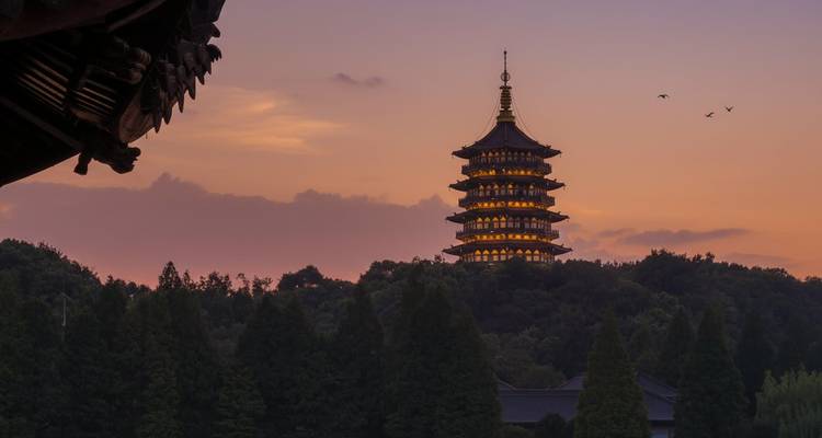 Pagoda Leifeng al atardecer rodeada de árboles.