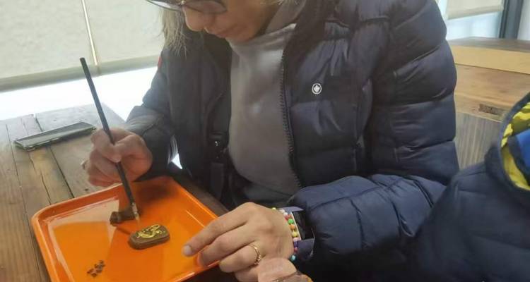 Persona decorando un objeto con palillos.