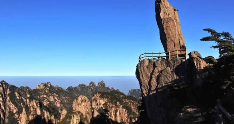 Pico montañoso afilado con una barandilla de mirador.