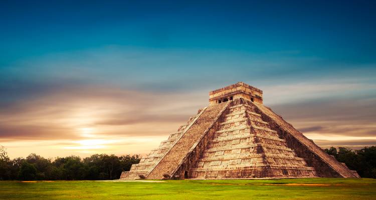 Chichen Itza Pyramide unter einem dramatischen Himmel bei Sonnenuntergang.