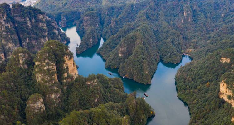 Vue aérienne d'une rivière serpentant à travers des canyons boisés.