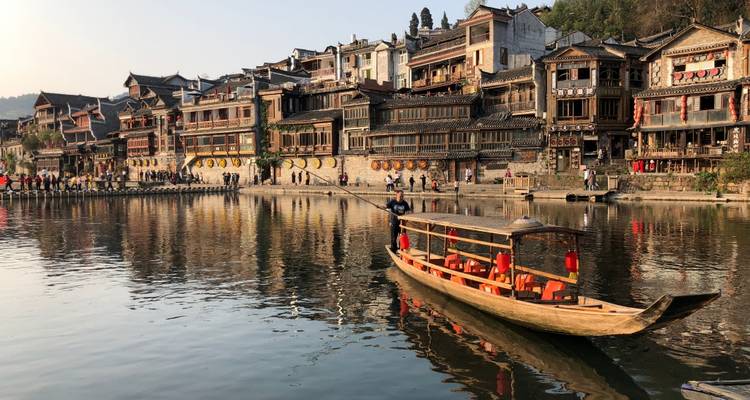 Village traditionnel au bord de la rivière avec des bateaux en bois.