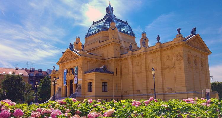 Kunstpaviljoen gebouw met oude architectuur en kleurrijke bloemen.