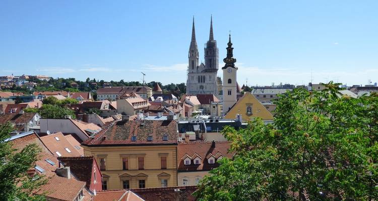 Panoramisch uitzicht op een stad met kerktorens en woonhuisdaken.