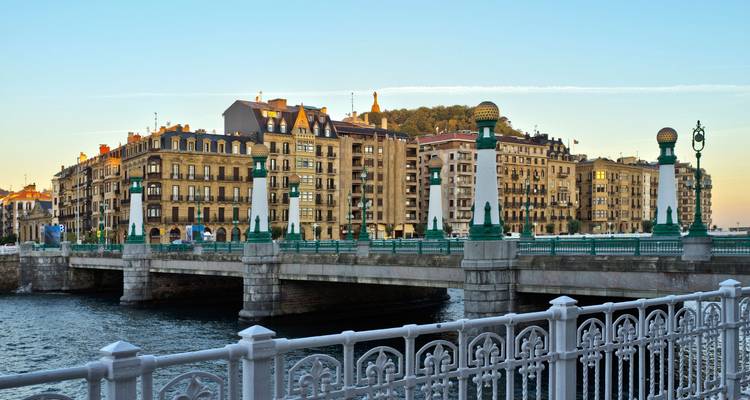 Bridge over river with historic buildings in San Sebastián.