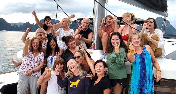 Groupe de personnes posant joyeusement sur un yacht.