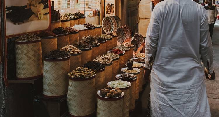 Kruidenmarkt met verschillende artikelen uitgestald, bezoeker aan het rondkijken.