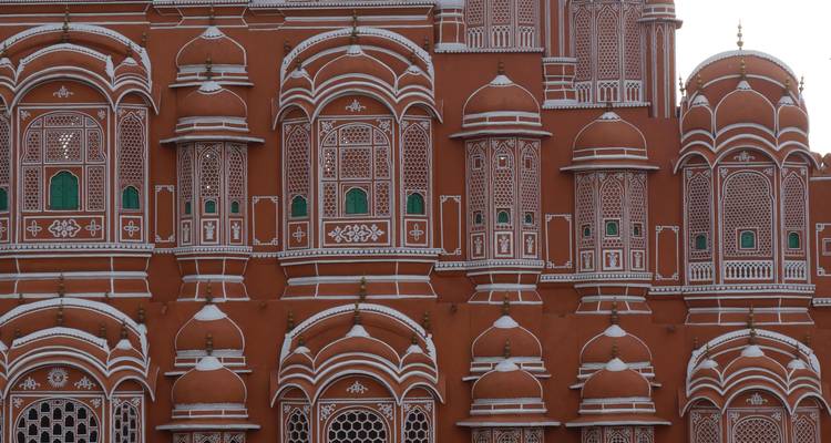 Facade of a pink architectural structure with intricate designs.