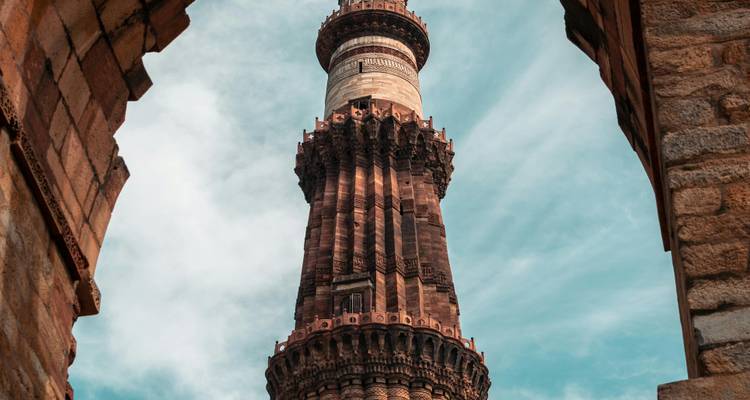 Qutub Minar seen through an archway.