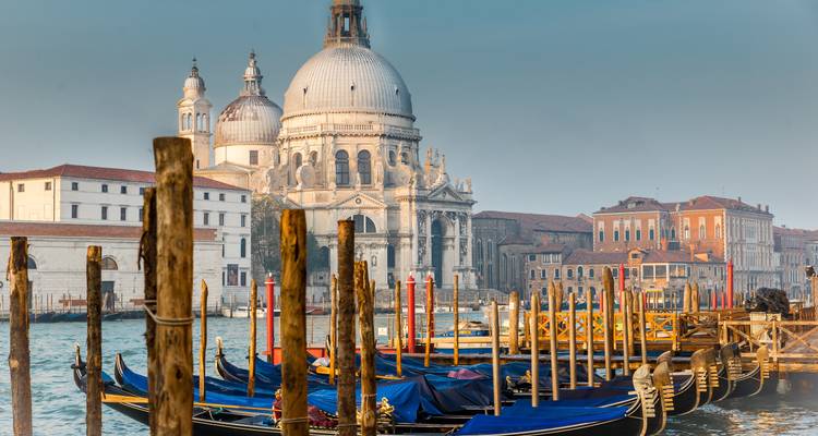 Gondolas docked by historic buildings in Venice