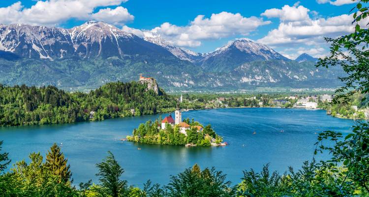 Lake with an island and church in the middle, surrounded by mountains.