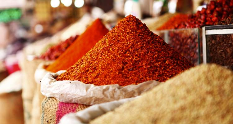 Vibrant pyramid of ground red spices in an open market stall