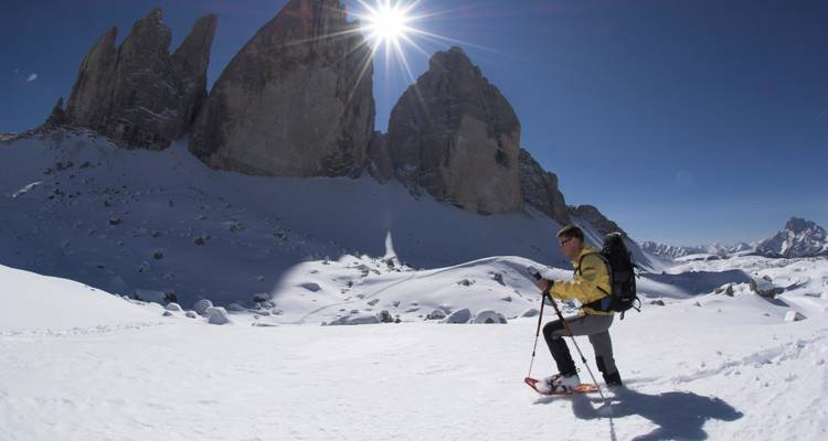 Skier with dramatic rock formations and bright sunshine.