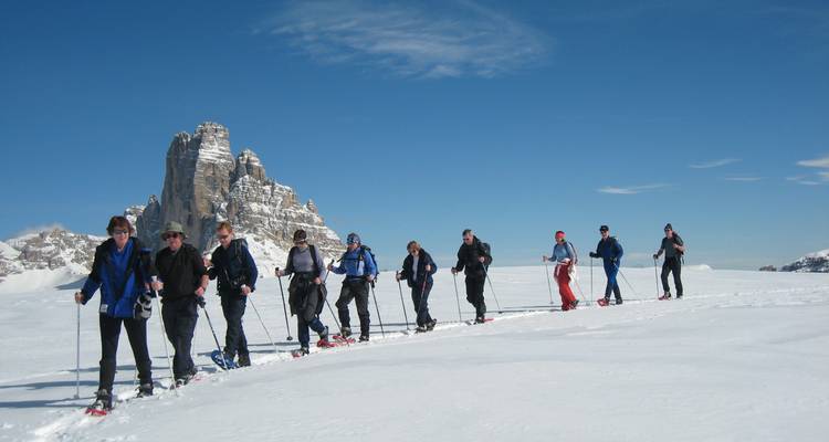 Line of skiers on a snow-covered mountain ridge.
