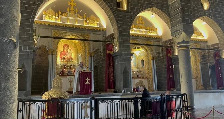 Intérieur d'une église ornée avec des personnes assistant à un service religieux.