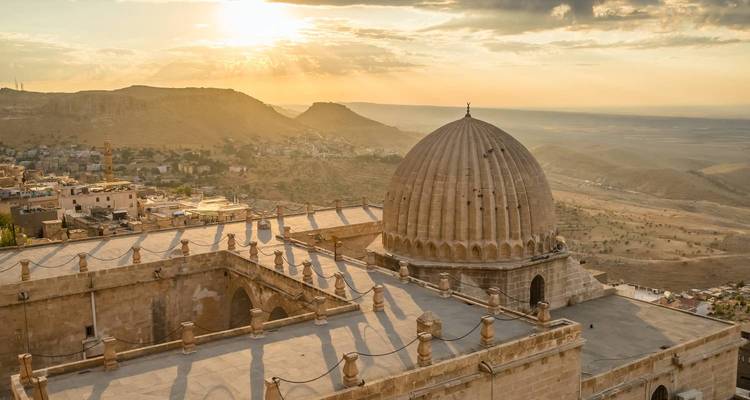 Vue du coucher de soleil sur une mosquée à Mardin avec un paysage étendu.
