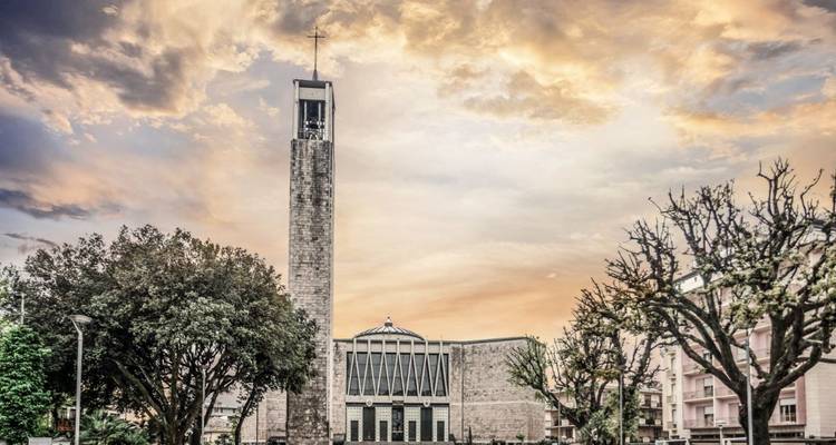 Une impressionnante structure d'église avec une haute tour et un ciel dramatique.